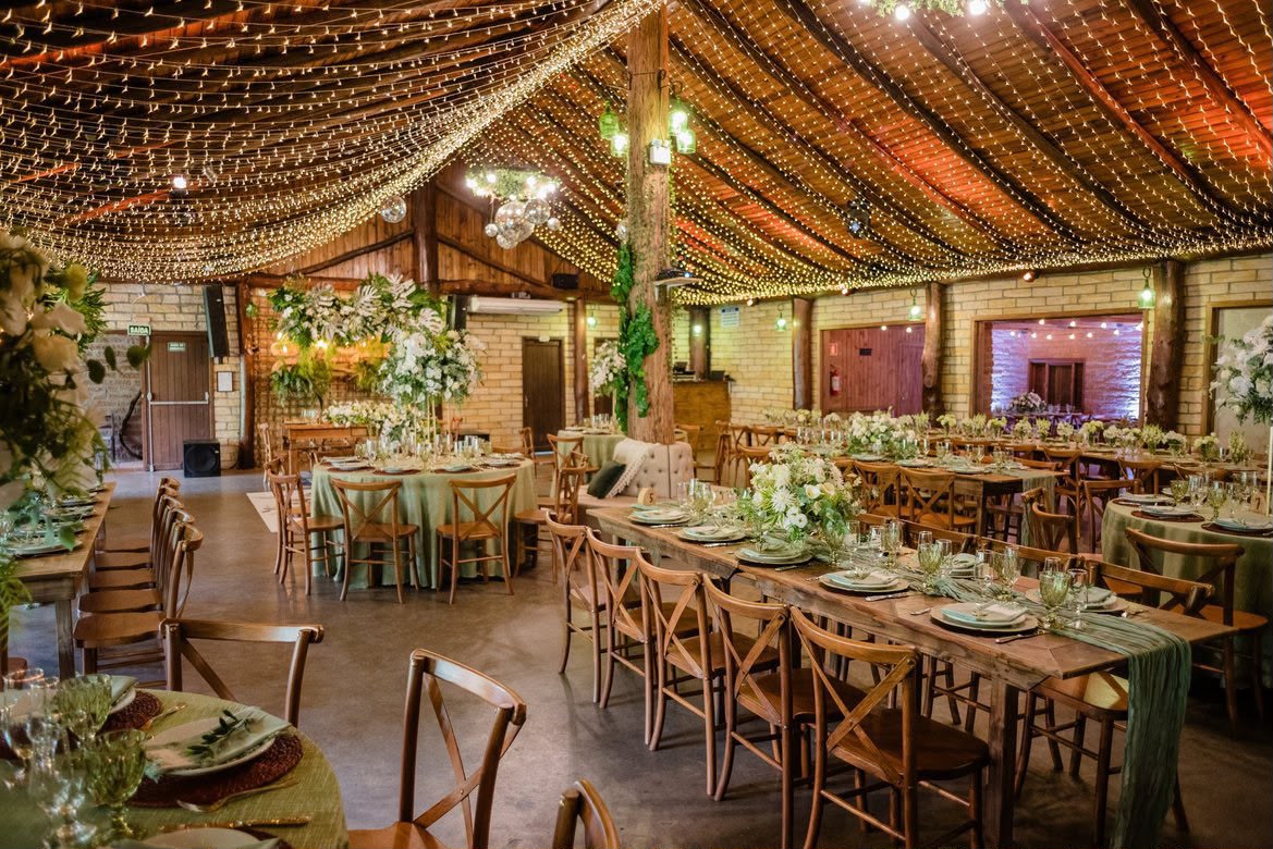 Salão principal decorado com mesas e luzes de festão