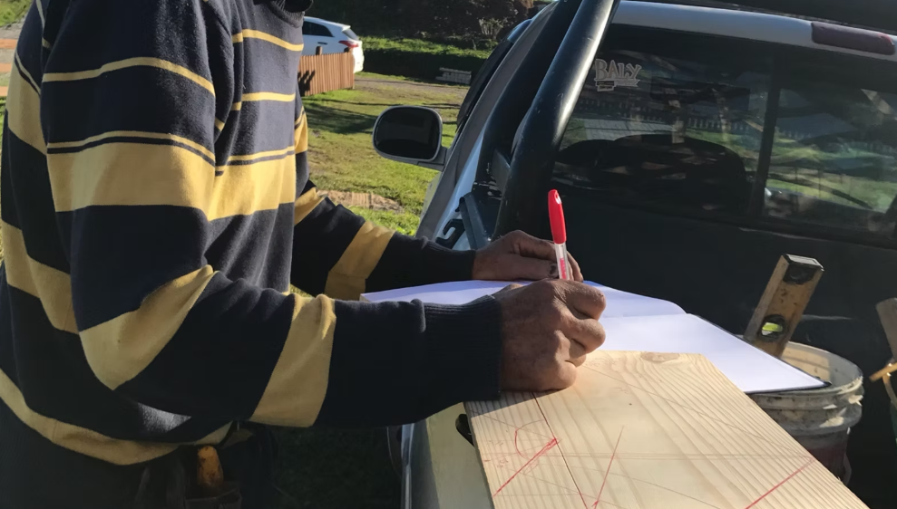 Marceneiro desenhando o projeto do celeiro