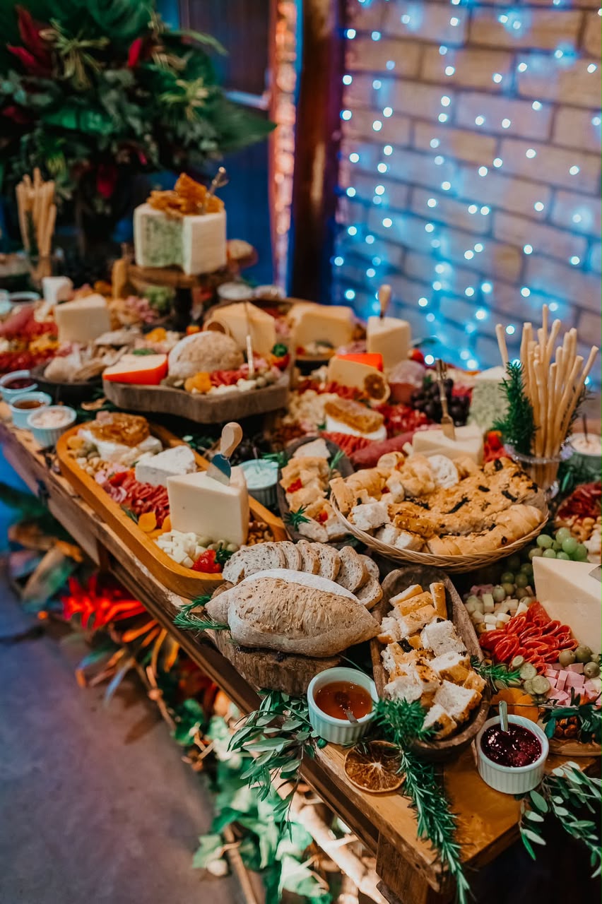 Mesa de frios, queijos e pães montada para recepção de casamento